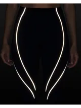 Calza deportiva de tiro alto en color negro, confeccionada en tejido elástico con costuras termoselladas y detalles de cinta reflectante a lo largo de las piernas.