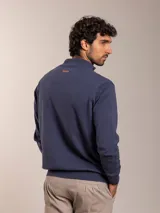 Campera color beige de tejido de punto con cierre frontal y cuello alto.
