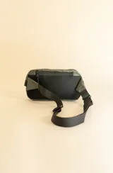 Riñonera negra con correa ajustable y logo estampado al frente.