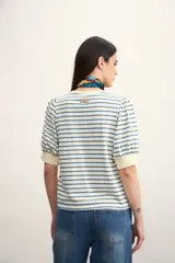 Remera de algodón con estampado de rayas horizontales en color verde claro sobre fondo blanco, con mangas cortas abullonadas y puños lisos.