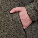 Campera de polar tipo sherpa en color verde oliva, con cuello alto, cierre frontal completo y bolsillo en el pecho con cierre en contraste negro. Cuenta con bolsillos laterales con cierre y tecnología Bonded para mayor retención térmica.