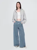 Jean baggy de tiro medio para mujer, con diseño de rayas verticales (pinstripe) en tonos azul índigo y blanco. Presenta un corte ancho y holgado de estilo relajado.