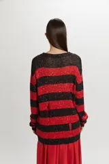 Buzo tejido de punto con diseño de rayas horizontales en negro y rojo, con acabado brillante de lentejuelas y detalles desgastados.