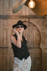 Chaleco negro de vestir con cuello en V y cierre frontal de tres botones dorados.