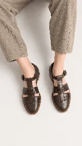 Sandalias tipo cangrejera de cuero color marrón, con diseño de tiras cruzadas y textura en la parte frontal. Cuentan con pulsera al tobillo con hebilla metálica y taco bajo.