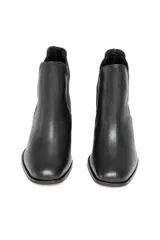 Botín tipo Chelsea confeccionado en cuero vacuno con textura floater. Presenta paneles laterales elásticos, punta ligeramente cuadrada y tacón de bloque.