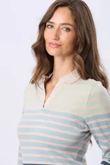 Remera polo de manga larga confeccionada en tejido de algodón con elastano. Presenta un diseño de rayas horizontales en tonos degradé, cuello tipo polo sin botones y un ajuste al cuerpo.