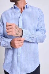 Camisa de corte regular con diseño de rayas verticales finas en tonos claros, cuello clásico y mangas largas con puños abotonados.
