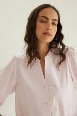 Camisa de algodón celeste con cuello mao, pechera con botones ocultos y mangas abullonadas con puños elásticos.
