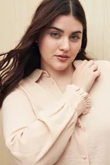 Camisa color café con textura sutil, cuello clásico, botones forrados a tono y mangas largas con puños fruncidos.