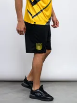 Short deportivo negro con logo del Club Atlético Peñarol bordado en amarillo en la pierna izquierda.