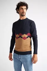 Sweater de punto con diseño color block, combinando azul marino en la parte superior, un patrón geométrico en tonos bordó y azul en el centro, y color camel en la parte inferior. Presenta cuello redondo y mangas largas.