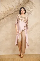 Túnica de satén color rosa pálido con estampado animal print en tonos marrones, corte asimétrico, terminaciones desflecadas y botones de coco.