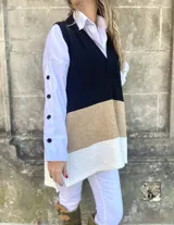 Chaleco largo tejido a rayas horizontales en color negro en la parte superior, tostado en el medio y blanco en la parte inferior.