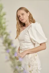 Top blanco de un solo hombro con manga abullonada.