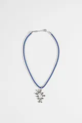 Gargantilla de cuero sintético azul con dije colgante metálico de diseño abstracto e irregular.