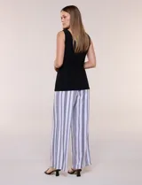 Enterito de efecto dos piezas con parte superior negra lisa, escote en V y sin mangas, y parte inferior de pantalón palazzo de corte amplio con diseño a rayas en blanco y negro. Cuenta con cintura entallada con lazo ajustable.