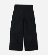 Pantalón cargo de corte mega baggy, color negro, confeccionado en sarga de algodón. Presenta múltiples bolsillos funcionales y un diseño versátil que permite transformar la prenda en bermuda mediante un sistema de ajuste en las piernas.