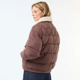 Campera acolchada corta color marrón con cuello de borreguito color crema. Presenta cierre frontal con botones a presión y bolsillos con solapa en el pecho.