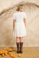 Vestido corto blanco de algodón broderi con mangas abullonadas y escote con lazo.