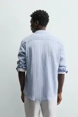 Camisa de hombre de manga larga, cuello italiano y corte regular fit, confeccionada en tejido de lino a rayas verticales azules y blancas.