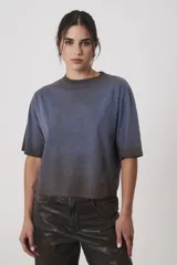 Remera de silueta amplia con escote redondo y mangas cortas, confeccionada en algodón con efecto de lavado desgastado en tonos azul y marrón.