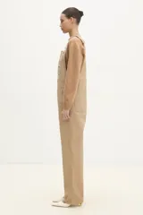 Mono color beige de corte recto, con cintura normal con cierre de botón, pierna recta de largo completo, dos bolsillos laterales oblicuos, dos bolsillos deslizantes en la parte inferior y bolsillo tipo canguro en la parte delantera.
