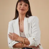 Esclava de alambre redondo en oro 9k, de diseño minimalista, con una medalla colgante que presenta un diseño grabado en forma de estrella con una circonia incrustada.