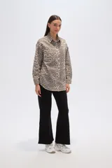 Chaqueta de algodón con estampado de leopardo en tonos grises y beige, corte ancho tipo camisa (shacket), con cuello camisero, botones frontales y bolsillos de parche en el pecho.