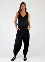 Pantalon negro de viscosa con pinzas en la cintura, bolsillos laterales y botamangas ajustadas.