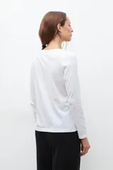 Remera de manga larga con escote redondo, confeccionada en tejido de algodón liso.