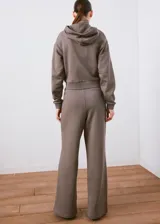 Campera con capucha y cierre frontal de cremallera, de color gris topo, con bolsillos canguro y diseño corto.
