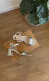 Sandalias de taco cuadrado bajo en color plateado, con diseño de punta cuadrada y tira ajustable con hebilla en el tobillo.