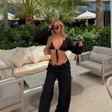 Pantalón negro de tiro alto y corte palazzo con cordón ajustable en la cintura.