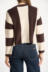 Sweater de tejido de punto grueso, con diseño de rayas verticales anchas en tonos marrón oscuro y negro. Presenta cuello redondo y mangas largas.