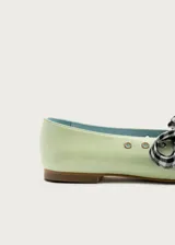 Bailarina de piel natural en color verde menta, con diseño de punta redondeada y detalle de ojales metálicos. Incluye un lazo desmontable de tela con estampado de cuadros vichy en blanco y negro.