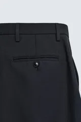 Pantalón de corte recto confeccionado en tejido con mezcla de algodón y lana. Presenta bolsillos laterales, bolsillos traseros de doble vivo con botón y cierre frontal con cremallera y botón.