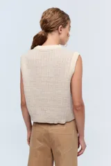 Chaleco de tejido de punto color crudo, con cuello a la base y lurex.
