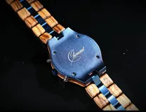 Reloj de pulsera Chenaut modelo Ocean, con caja y malla combinadas en madera de Zebrano africano y acero inoxidable azul. Presenta una esfera azul con subdiales de madera, indicador de fase lunar, fechador y bisel técnico tipo buzo.