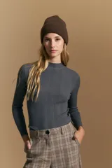 Polera de punto acanalado color gris, con cuello alto y mangas largas, de calce ajustado al cuerpo.