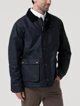 Chaqueta de estilo campestre confeccionada en tela encerada impermeable y cortaviento. Presenta cierre frontal con botones a presión, cuello alto con interior de cotelé, bolsillos frontales con solapa y forro interior de franela con relleno térmico.
