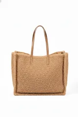 Cartera tipo tote bag de textura de corderito sintético en color tostado, con asas largas de cuero sintético al tono.