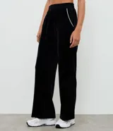 Pantalón deportivo de corte recto confeccionado en tejido de plush, con cintura elástica y detalle de piping lateral contrastante.