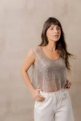 Top corto sin mangas, confeccionado en tejido de red con aplicación de strass plateado. Presenta escote redondo, diseño translúcido y calce suelto.