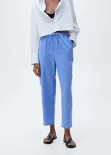 Pantalón de corte recto confeccionado en mezcla de lino y algodón, con cintura elástica y lazo ajustable. Presenta tiro medio y diseño largo.