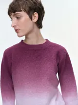 Buzo tejido de punto con diseño degradé que transiciona de azul oscuro a celeste claro. Presenta cuello redondo, mangas largas y puños acanalados, con un corte holgado y relajado.