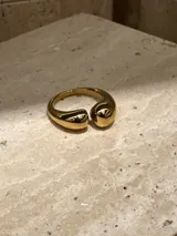Anillo abierto de acero quirúrgico con diseño de superficie irregular y acabado brillante.