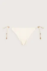 Calzón de bikini color crema, con diseño de tiras laterales ajustables y detalles de cuentas metálicas doradas en los extremos.