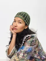 Gorro tipo casquete verde oliva, tejido al crochet con diseño calado.