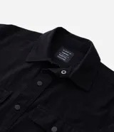 Camisa manga larga de sarga en color verde militar, con cuello inglés, cierre frontal de botones negros y dos bolsillos con solapa en el pecho.